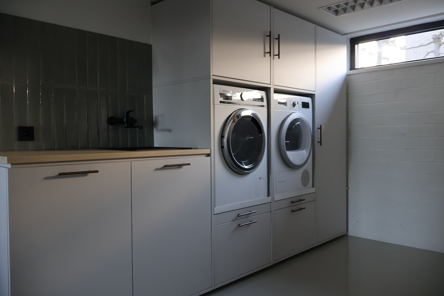 Waschmaschinenschrank in Steingrau mit Spüle Moderner Waschmaschinenschrank in Steingrau mit schönen Unterschränken mit Spüle